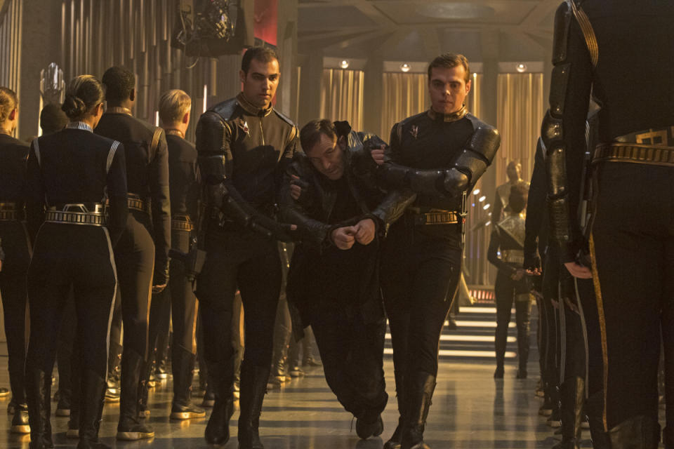 Captain Gabriel Lorca (Jason Isaacs) is escorted through the Terran Emperor's ship in Episode 12 of "Star Trek: Discovery." <cite>Ben Mark Holzberg/CBS</cite>